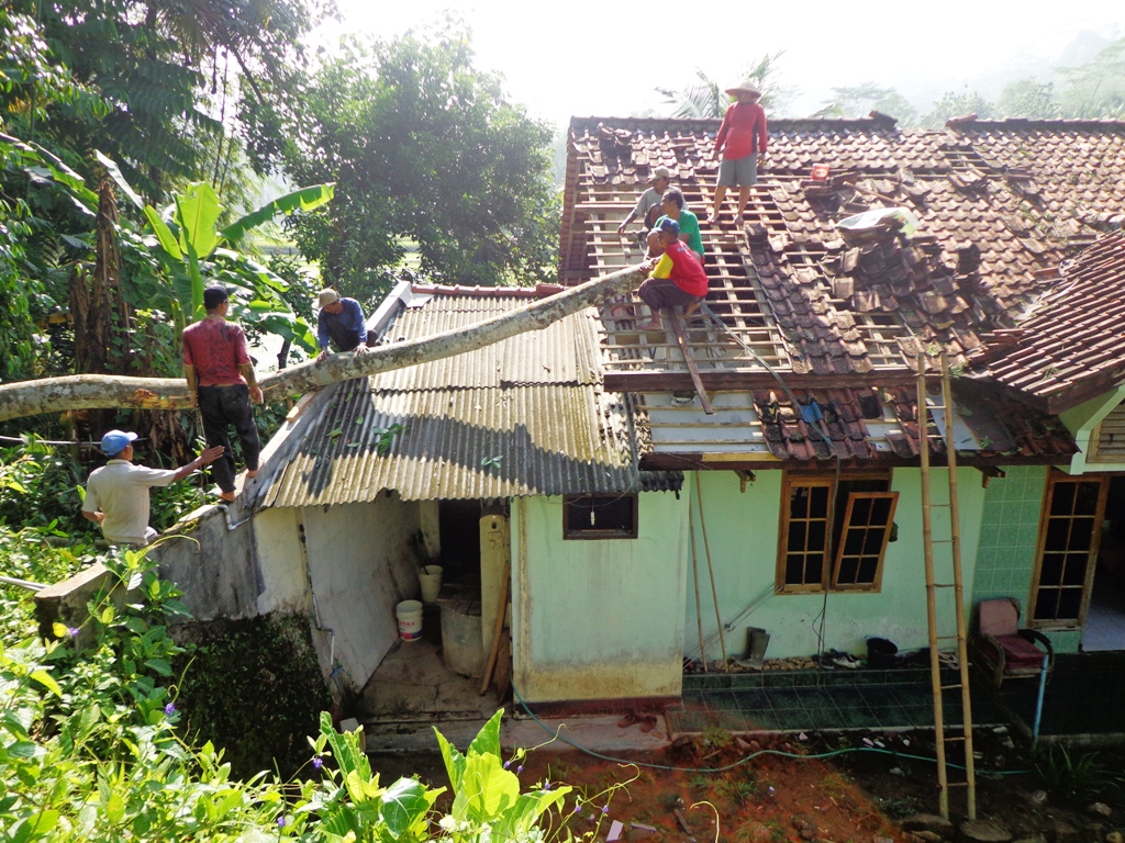 Rumah milik Turmudi (58) sedang diperbaiki warga usai tertimpa pohon, Minggu (6/3) kemarin