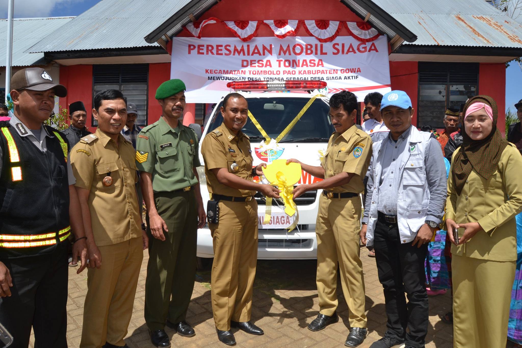 Penyerahan secara simbolis kunci Mobil Siaga kepada Wakil Ketua Desa Siaga Desa Tonasa oleh Camat Tombolo Pao yang didampingi oleh Kepala Desa Tonasa, Kepala Puskesmas Tamaona, Dan Pos Ramil, Bhabinkamtibmas, dan Bidan Desa Tonasa. (Foto : facebook.com/desatonasa/posts/1761698750785148)